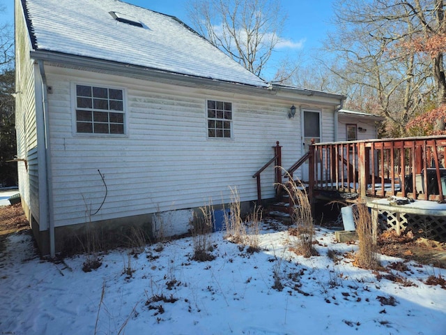 snow covered property featuring a wooden deck