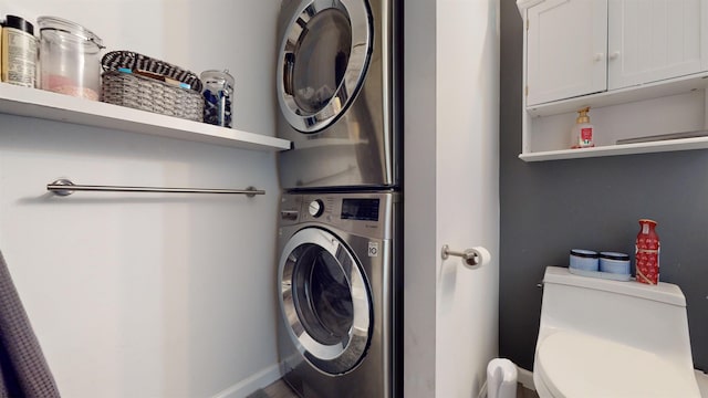 clothes washing area featuring stacked washing maching and dryer