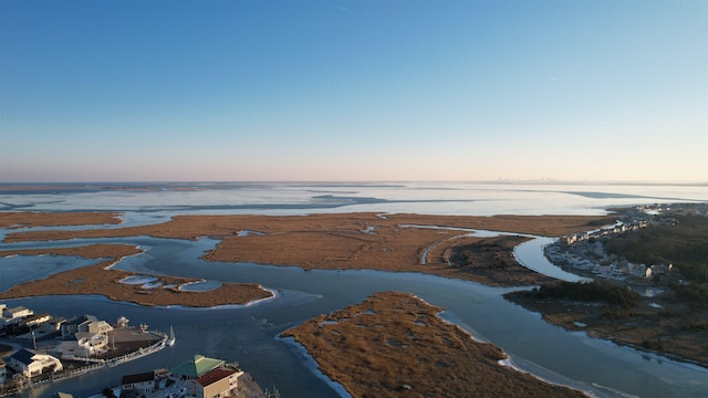 aerial view at dusk featuring a water view