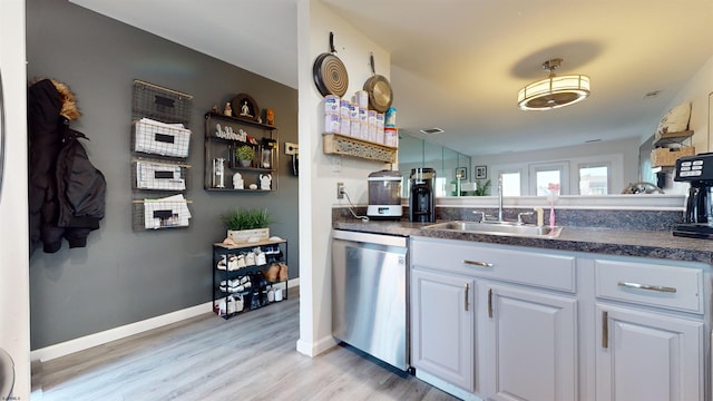 kitchen featuring light wood-type flooring, dishwasher, sink, and white cabinets