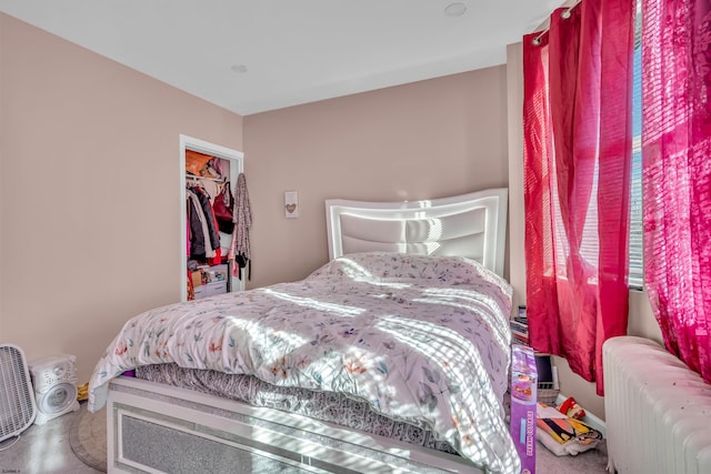 carpeted bedroom featuring radiator and a closet