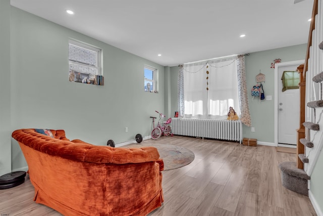 living room featuring radiator heating unit and light hardwood / wood-style floors