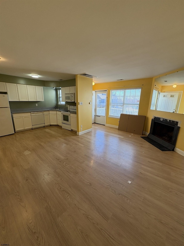 unfurnished living room with a wealth of natural light and light wood-type flooring