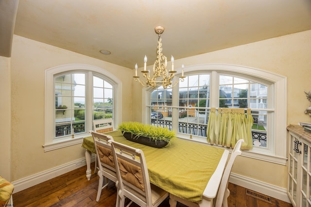 dining area with a healthy amount of sunlight, a chandelier, and dark hardwood / wood-style flooring