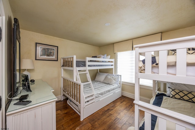 bedroom featuring a textured ceiling and dark hardwood / wood-style flooring