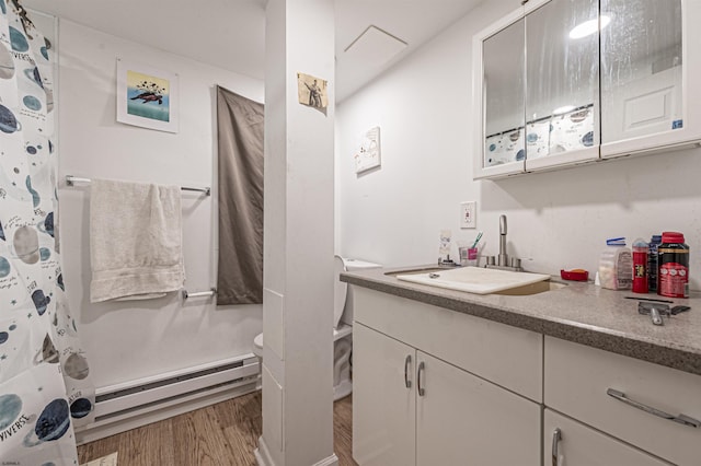 bathroom with baseboard heating, vanity, curtained shower, and hardwood / wood-style flooring