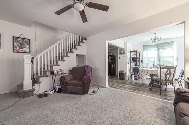 living room with carpet flooring and ceiling fan with notable chandelier