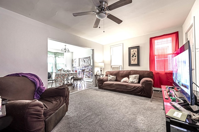 living room featuring hardwood / wood-style flooring and ceiling fan with notable chandelier