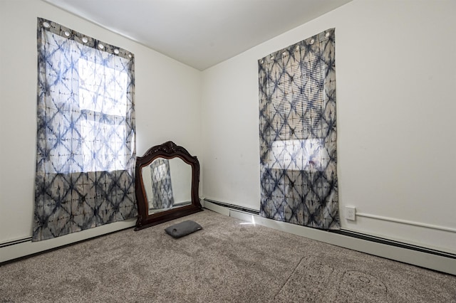 carpeted empty room with a baseboard heating unit