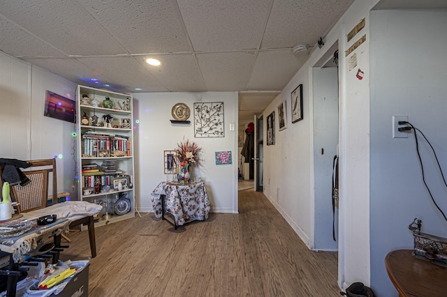 interior space with a paneled ceiling and wood-type flooring