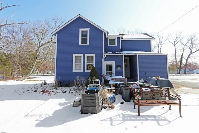 view of snow covered back of property