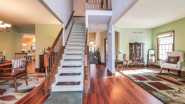 entrance foyer with dark hardwood / wood-style flooring and a notable chandelier