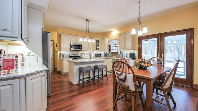 dining space with dark wood-type flooring, plenty of natural light, and ceiling fan