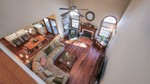 living room featuring ceiling fan, a towering ceiling, wood-type flooring, and sink