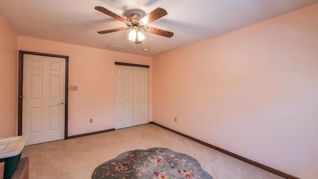 unfurnished bedroom featuring light colored carpet, a closet, and ceiling fan