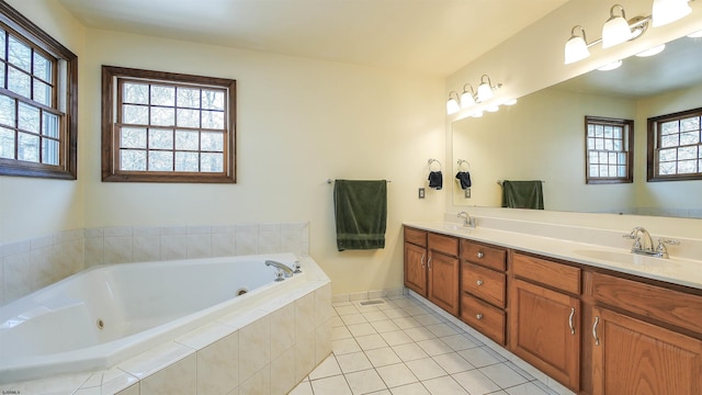 bathroom featuring tile patterned flooring, vanity, and a relaxing tiled tub