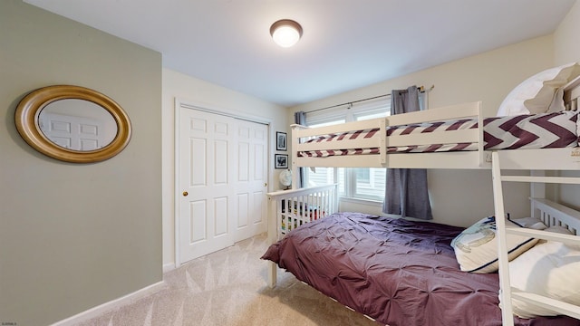 bedroom featuring light colored carpet and a closet