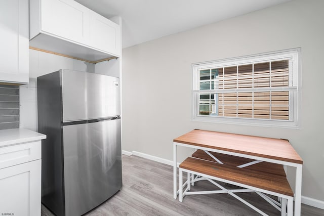 kitchen featuring white cabinetry, stainless steel fridge, and light wood-type flooring