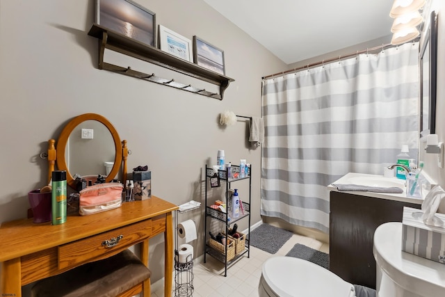 bathroom featuring vanity, curtained shower, and toilet