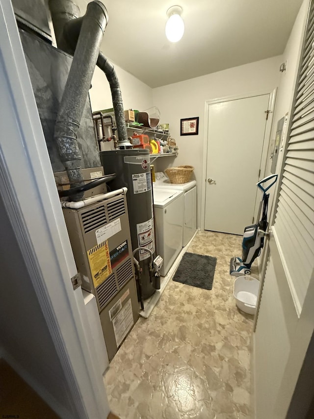 laundry room with water heater and washer and dryer