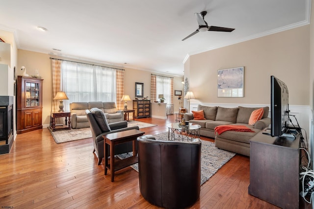 living room featuring crown molding, light hardwood / wood-style flooring, and ceiling fan