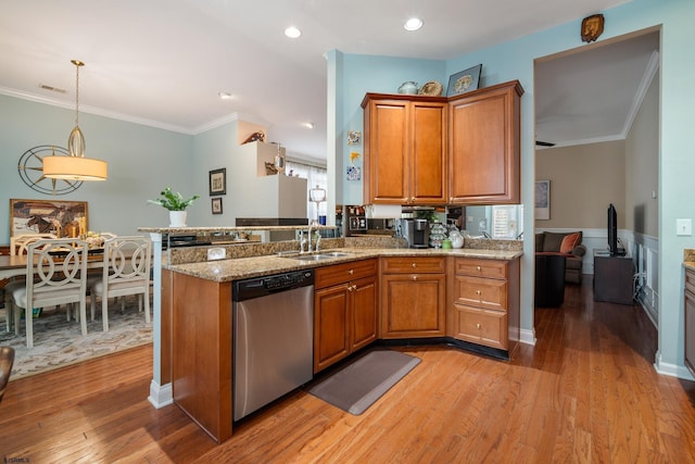 kitchen featuring pendant lighting, dishwasher, sink, and light hardwood / wood-style flooring