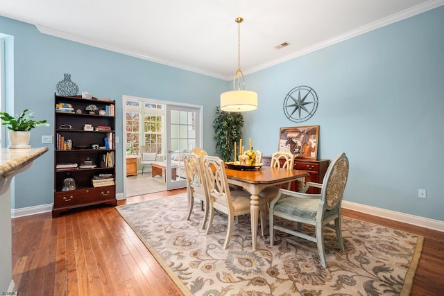 dining area with ornamental molding and hardwood / wood-style floors