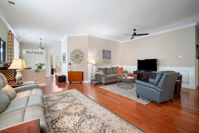 living room featuring crown molding, wood-type flooring, and ceiling fan