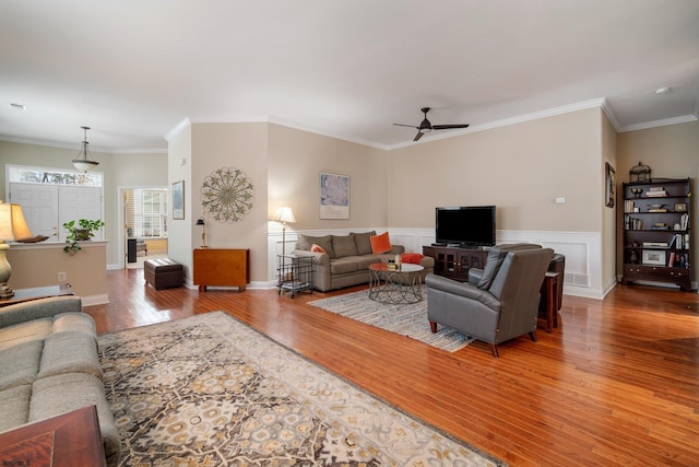 living room featuring hardwood / wood-style flooring, ornamental molding, and ceiling fan