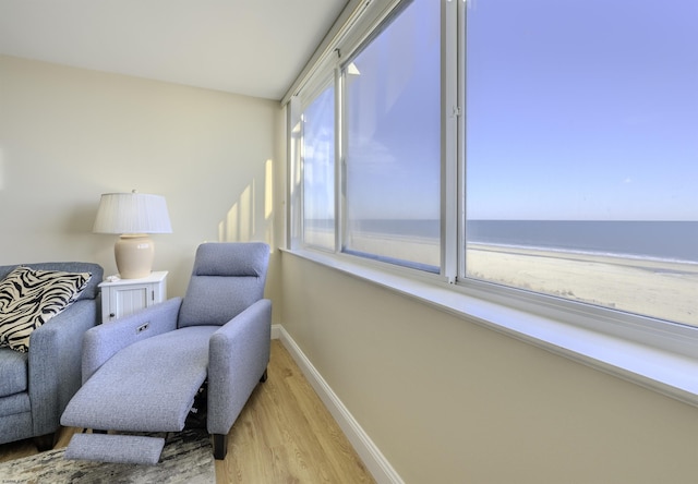 living area featuring a water view and light hardwood / wood-style flooring