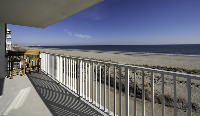 balcony featuring a water view and a view of the beach