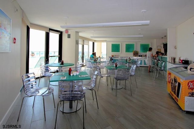 dining room with expansive windows, wood-type flooring, a wealth of natural light, and french doors