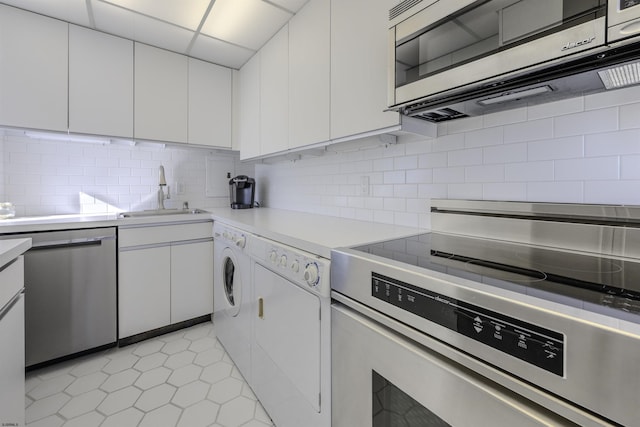 kitchen featuring white cabinetry, sink, backsplash, and appliances with stainless steel finishes