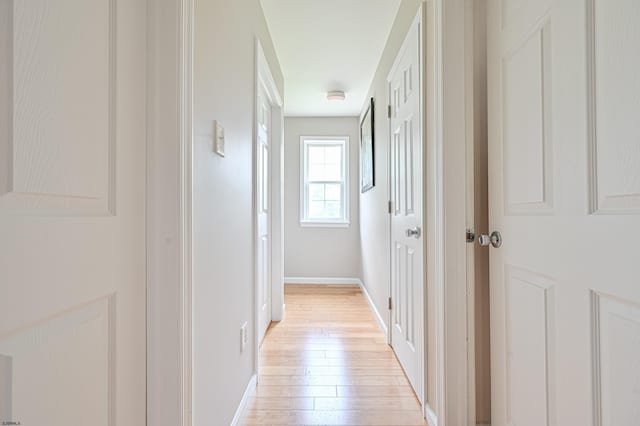 hallway with light hardwood / wood-style floors