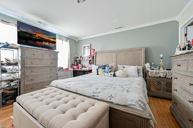 bedroom with ornamental molding and light wood-type flooring