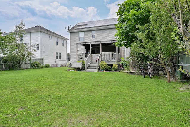 rear view of house with a wooden deck and a yard