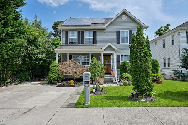 view of front of home with a porch, a front yard, and solar panels