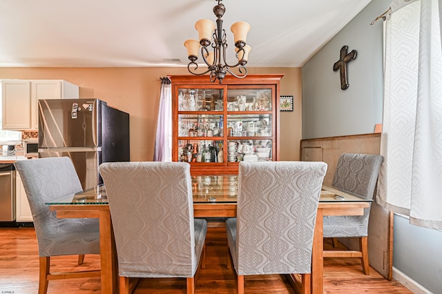 dining room featuring a notable chandelier and light wood-type flooring