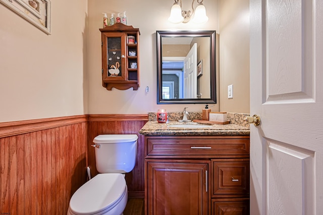 bathroom featuring vanity, a notable chandelier, and toilet