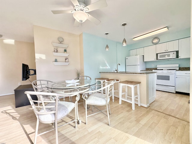 dining area featuring ceiling fan, sink, and light hardwood / wood-style floors