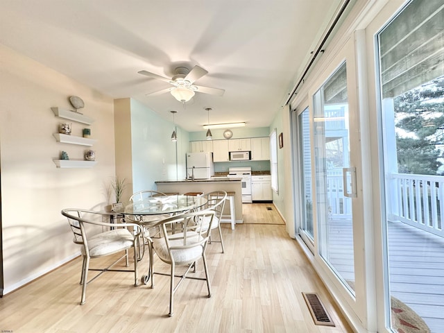 dining area with ceiling fan and light wood-type flooring