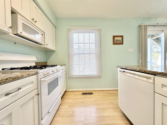 kitchen featuring light stone counters, white appliances, light hardwood / wood-style floors, and white cabinets