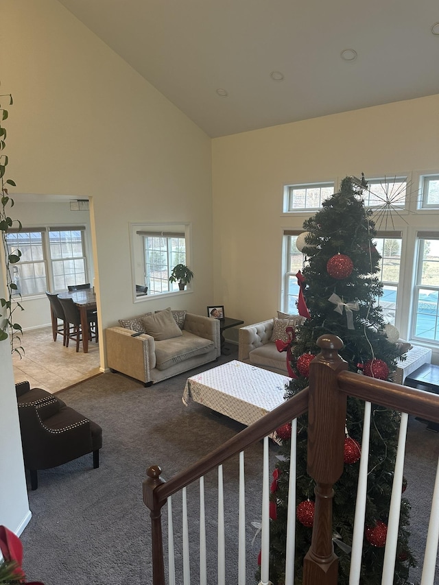 carpeted living room featuring high vaulted ceiling