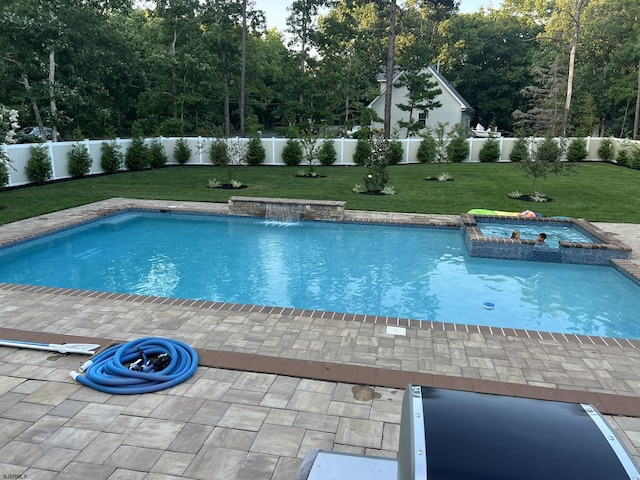 view of swimming pool featuring an in ground hot tub, pool water feature, a yard, and a patio area