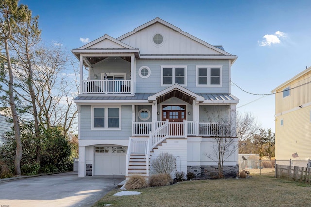 coastal home with a garage, a balcony, a porch, and a front lawn