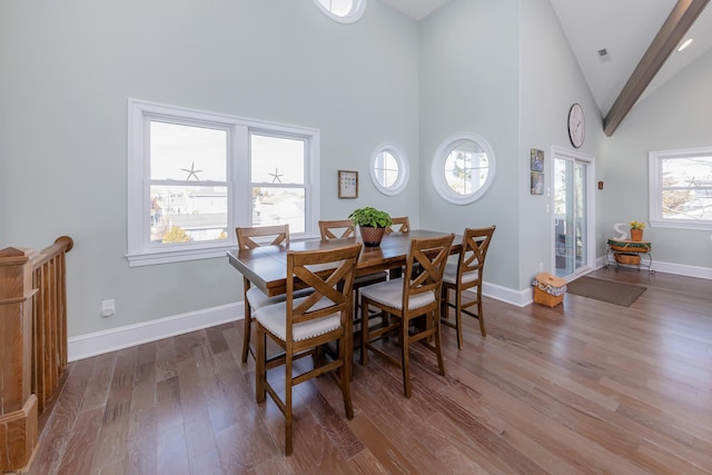 dining room with hardwood / wood-style floors and high vaulted ceiling