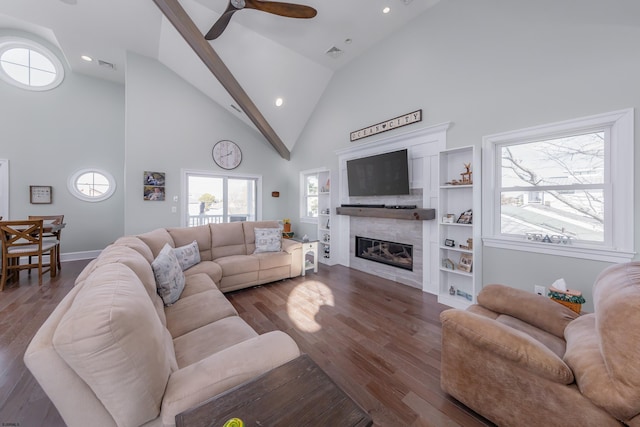 living room with ceiling fan, dark hardwood / wood-style flooring, high vaulted ceiling, and a tile fireplace