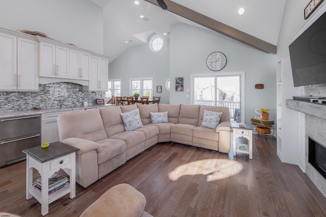 living room featuring hardwood / wood-style flooring, high vaulted ceiling, and a fireplace