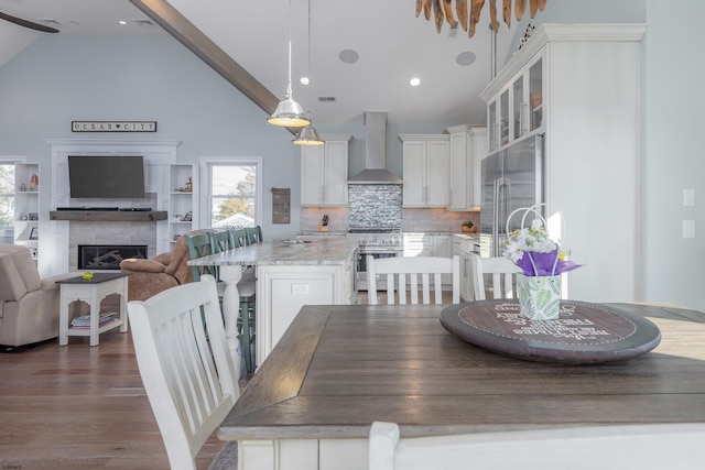 dining room featuring beamed ceiling, dark hardwood / wood-style flooring, and high vaulted ceiling