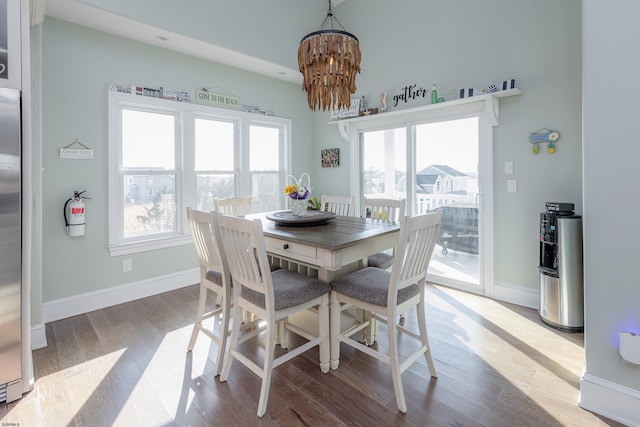 dining space with wood-type flooring and an inviting chandelier